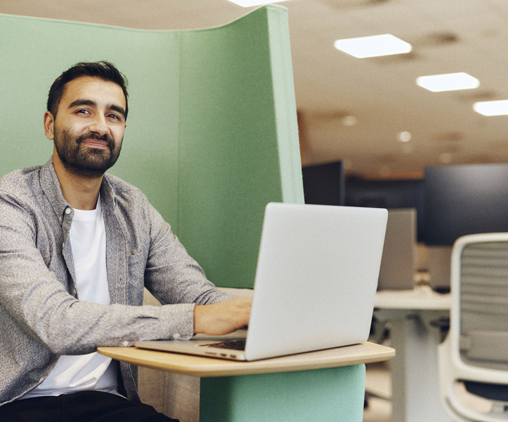 Person sat in office with open laptop